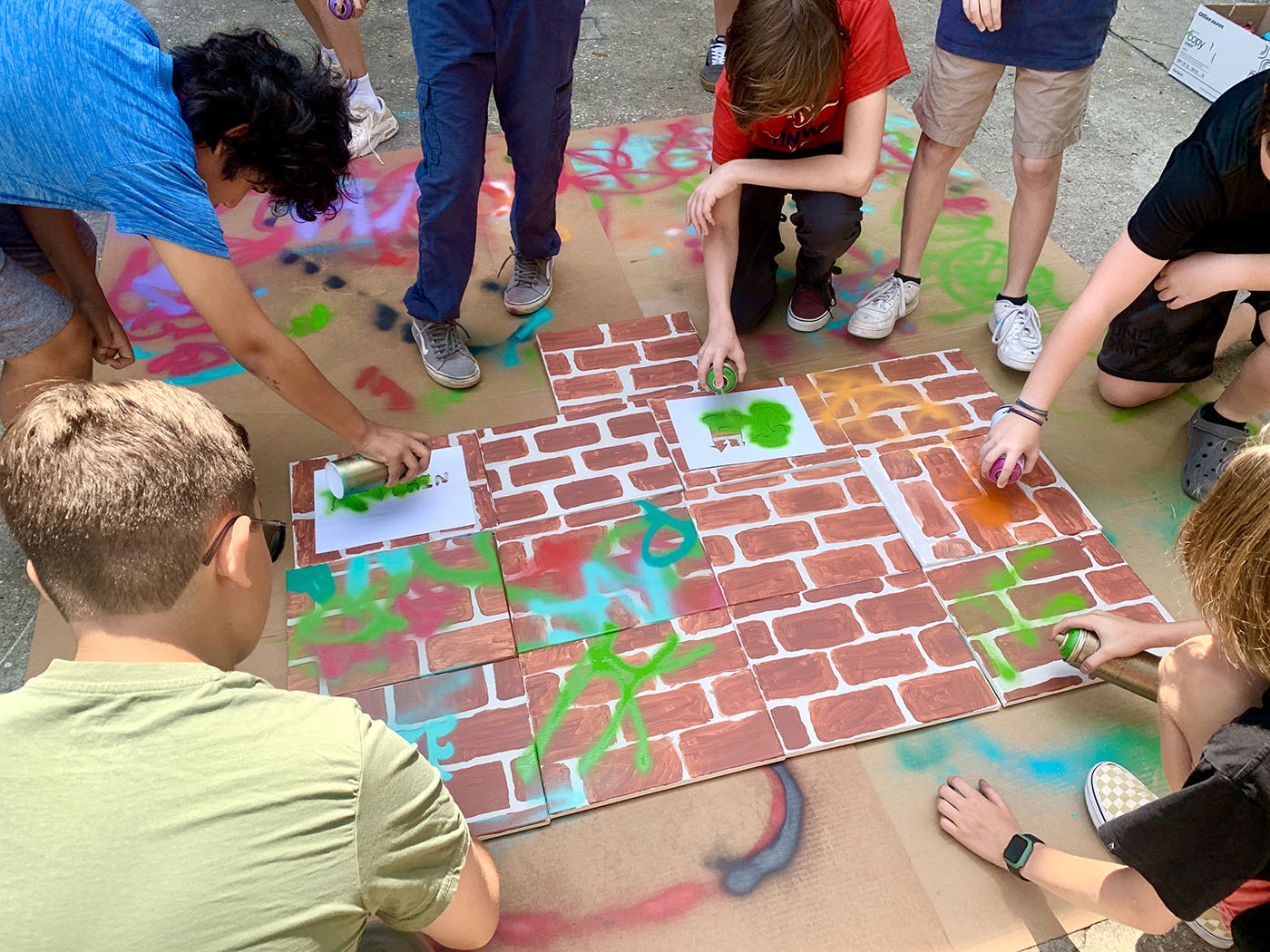 Students gathering to create a unique tag mural from handmade stencils.