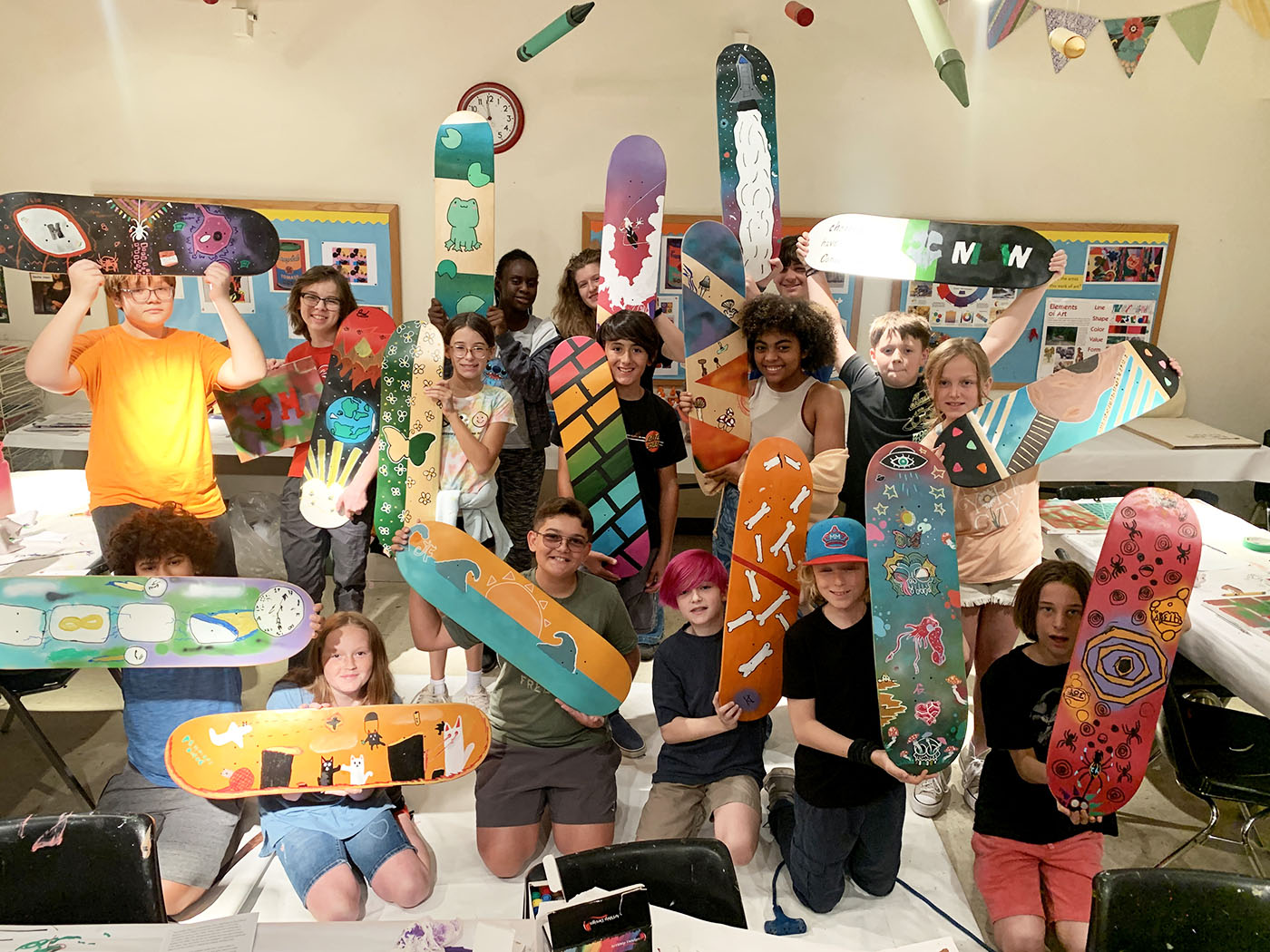 Students showing off their Skate Decks. This week's class is where students become fully immersed in the world of street art.